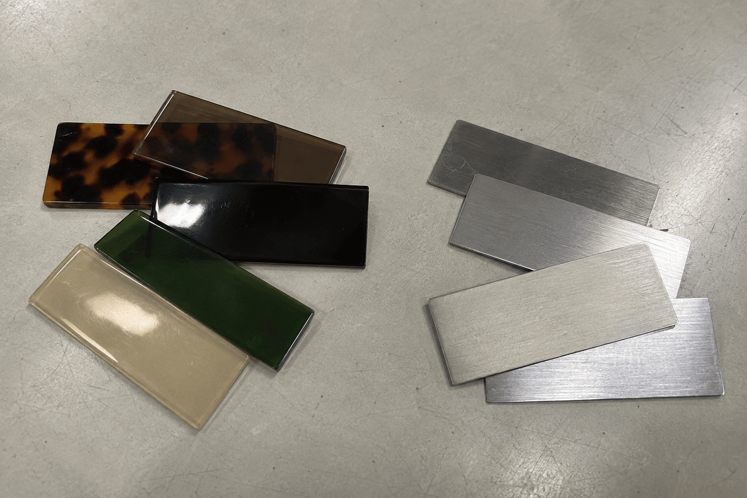 Acetate and metal sheet samples on a workshop table