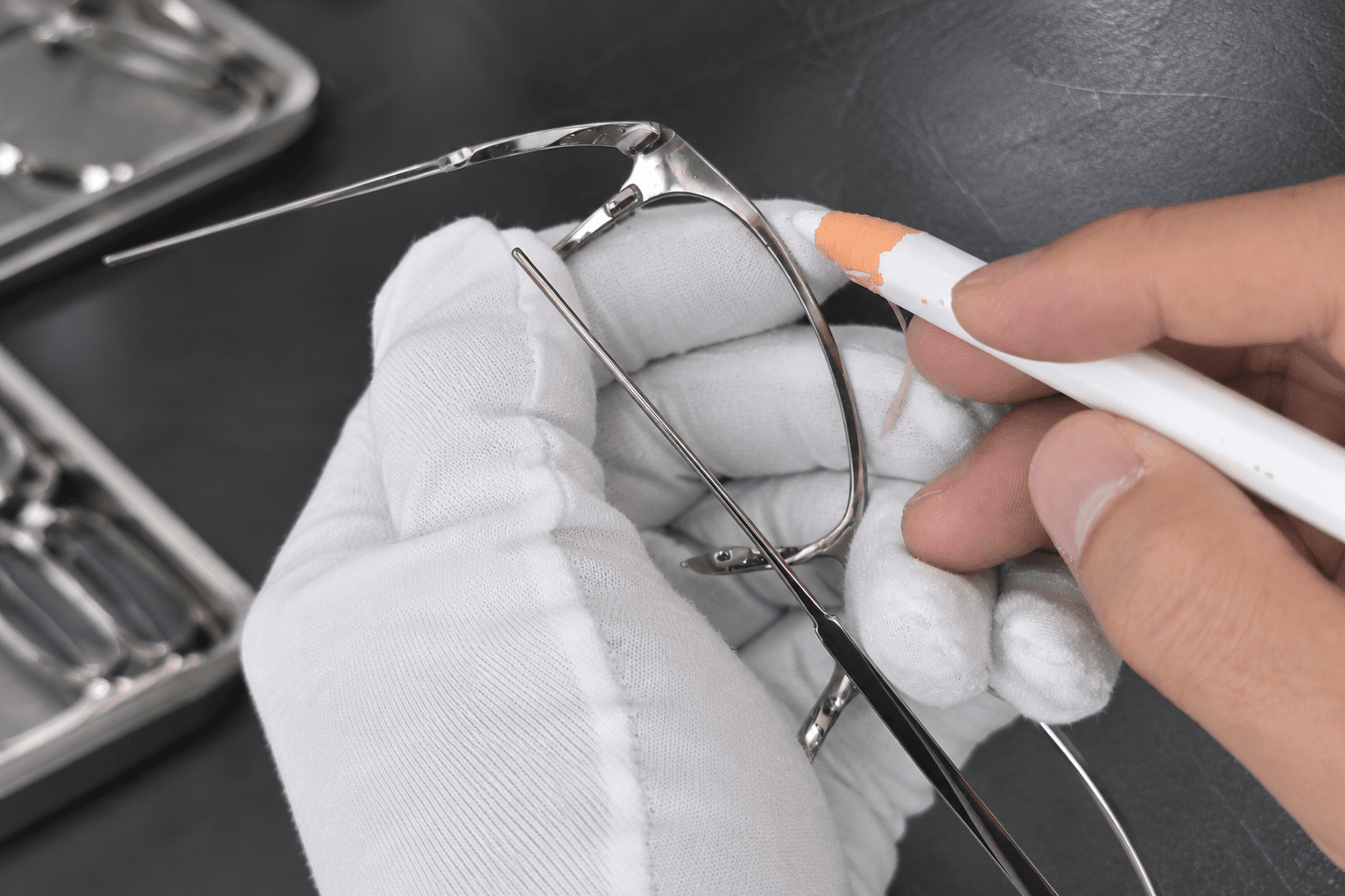 Gloved hands inspecting a semi-finished metal frame